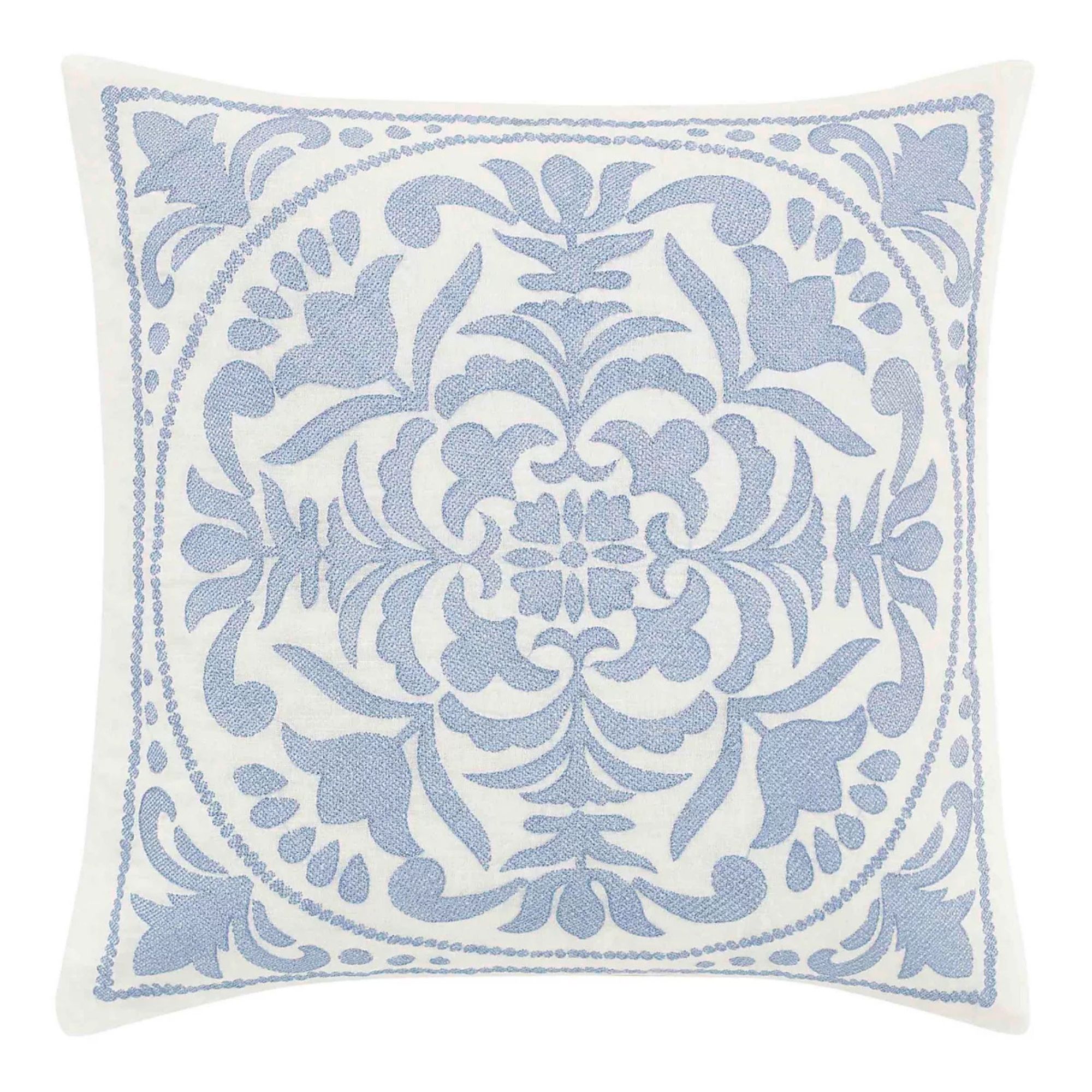 square throw pillow with blue embroidered design on white background