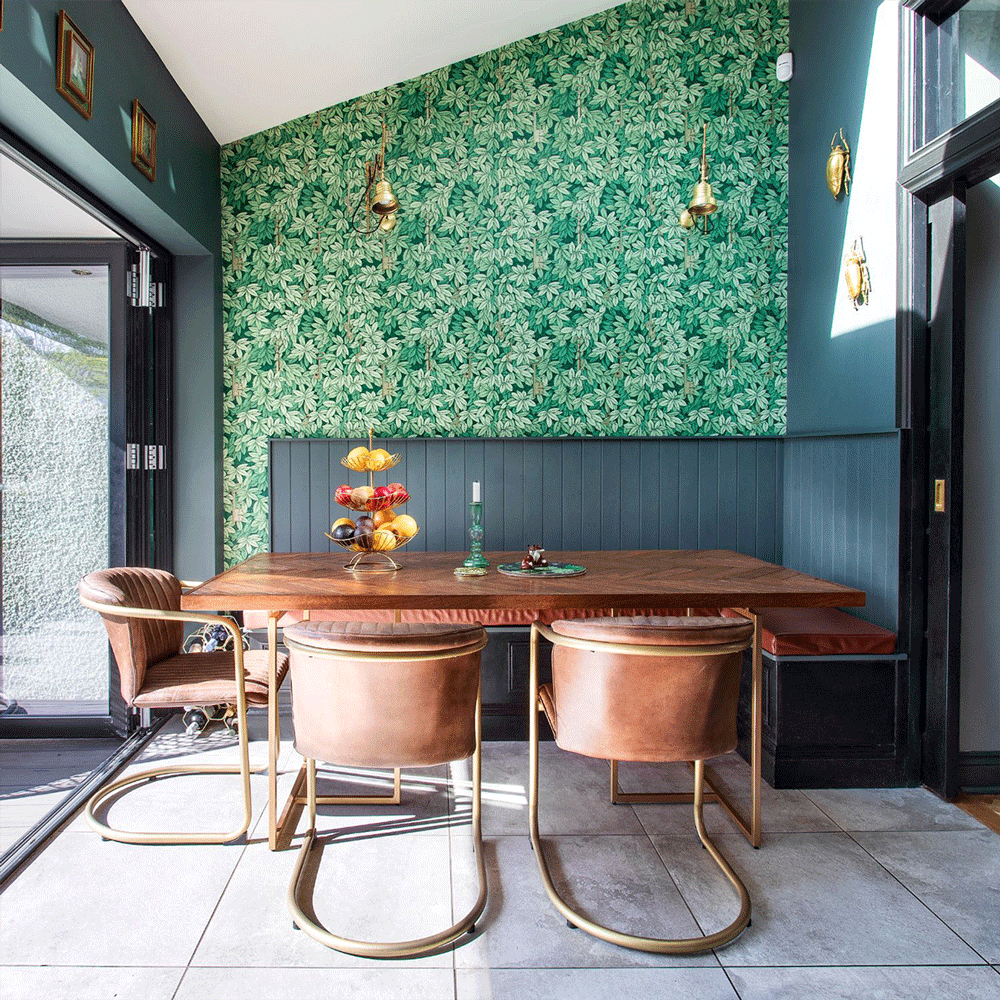 Dining area with green leaf wallpaper and wooden table