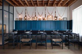 Tables, chairs, frames on the wall and wood beaded hanging lights at the Taub Family Outpost