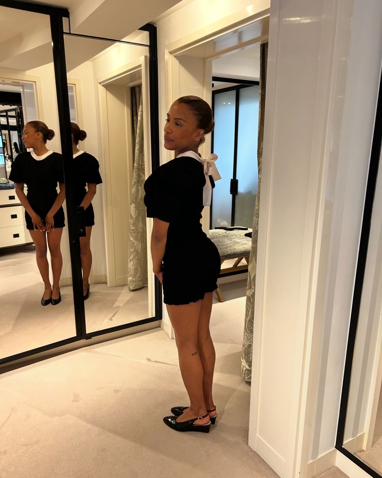A woman in a dressing room with a low bread hairstyle