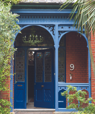 lilac blue painted front door and porch on brick house