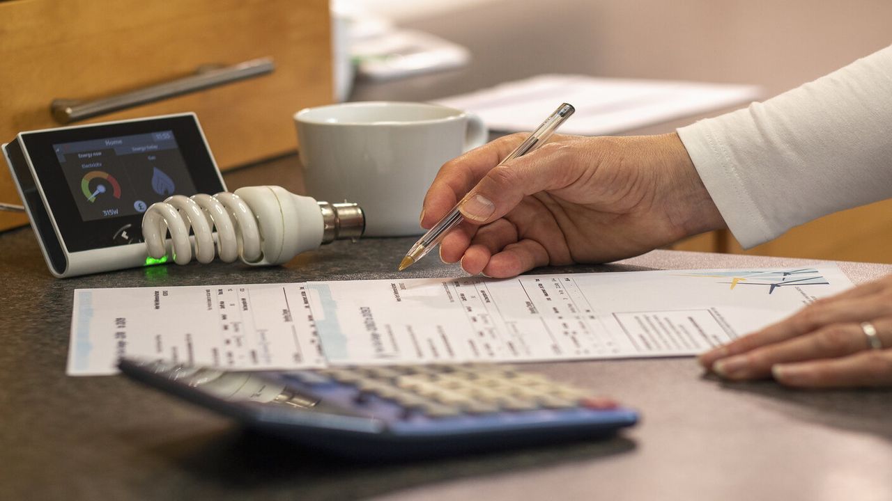 person looking at their bill with a calculator