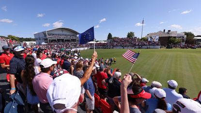 Fans wave flags in the grandstand at the Solheim Cup 1st tee