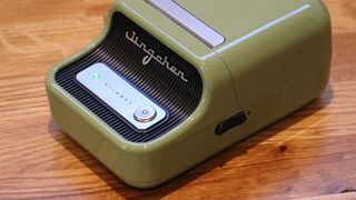 Niimbot B21 review; a small green label printer on a wooden table