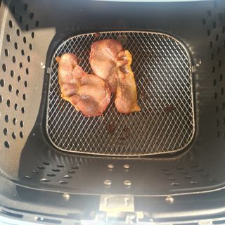 Close up of bacon in the basket of a Swan Retro air fryer