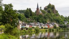 A lone cyclist rides his bike through a quaint German town