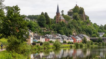 A lone cyclist rides his bike through a quaint German town