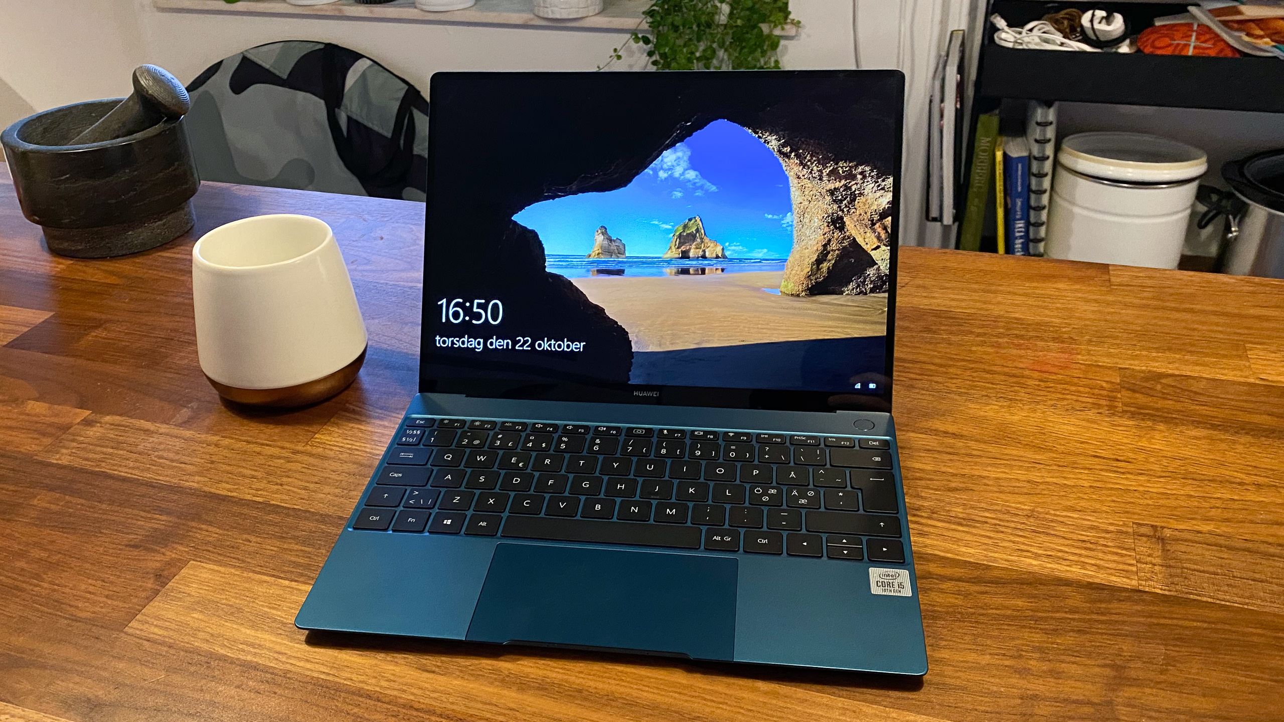 Huawei MateBook X (2020) på ett bord jämte en kaffekopp.