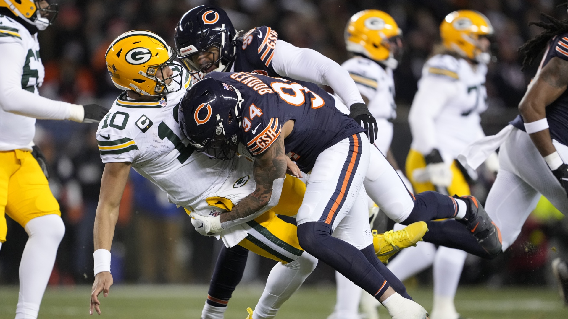 Jordan Love of the Green Bay Packers is hit after his pass by Austin Booker of the Chicago Bears