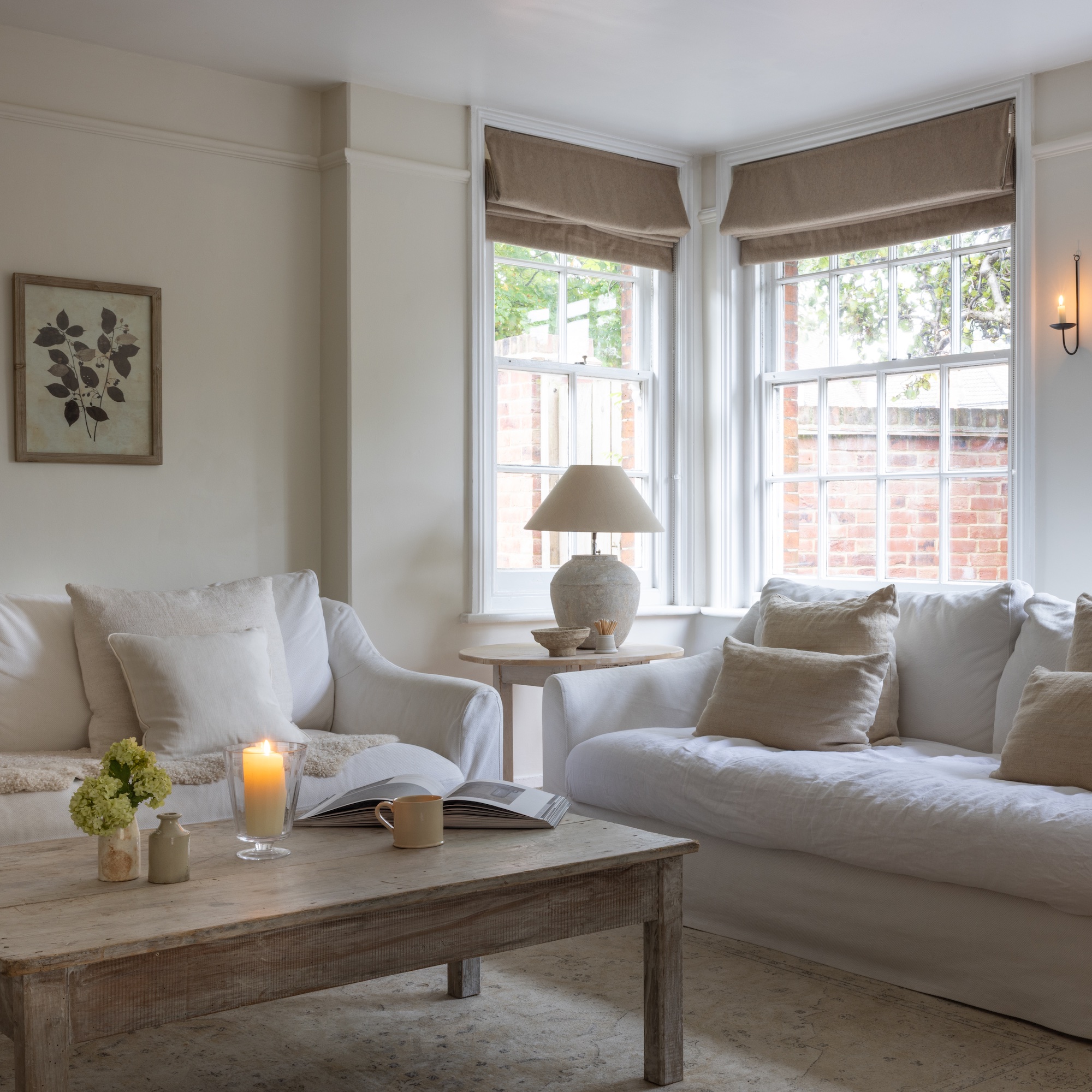 living area with bay window and two sofas covered in white linen loose covers