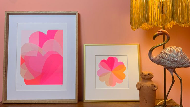 Shelf with flamingo lamp base and two pink artworks