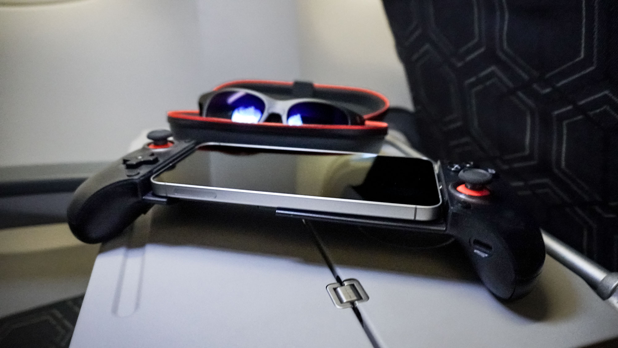 The Viture x 8BitDo Ultimate Mobile Gaming Controller and Viture XR glasses on an airplane tray table