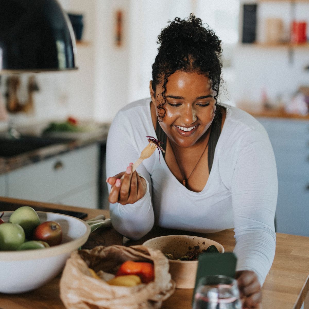 30-30-30 eating method: A woman following a healthy recipe on her phone in the kitchen