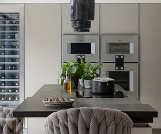 black kitchen island with a section of three small different levels at one end