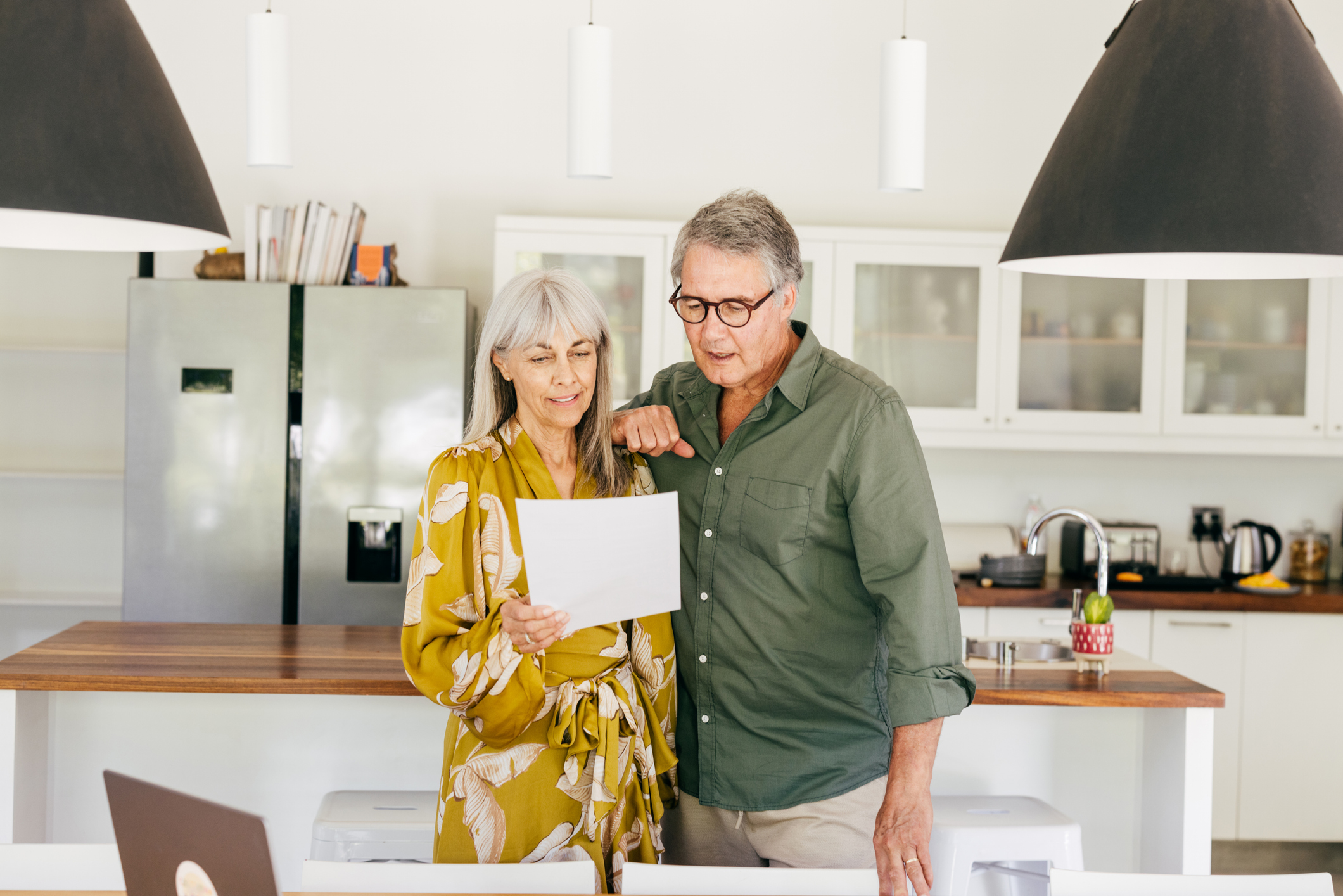 Older couple looking at documents in the kitchen