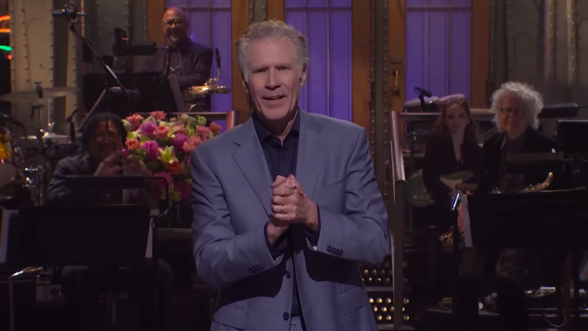 Will Ferrell hosting the Saturday Night Live season finale in 2026. He is wearing a gray suit 