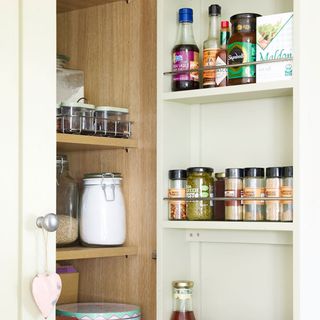 white llader cupboard with storage jars and kitchen spices