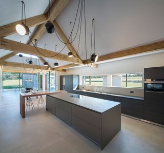 Kitchen with exposed beams, centre island and tiled floors