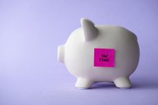 piggy bank with tax time post it on it
