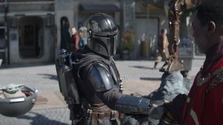 din djarin shaking hands with greef karga with grogu in the background in The Mandalorian season 3 trailer