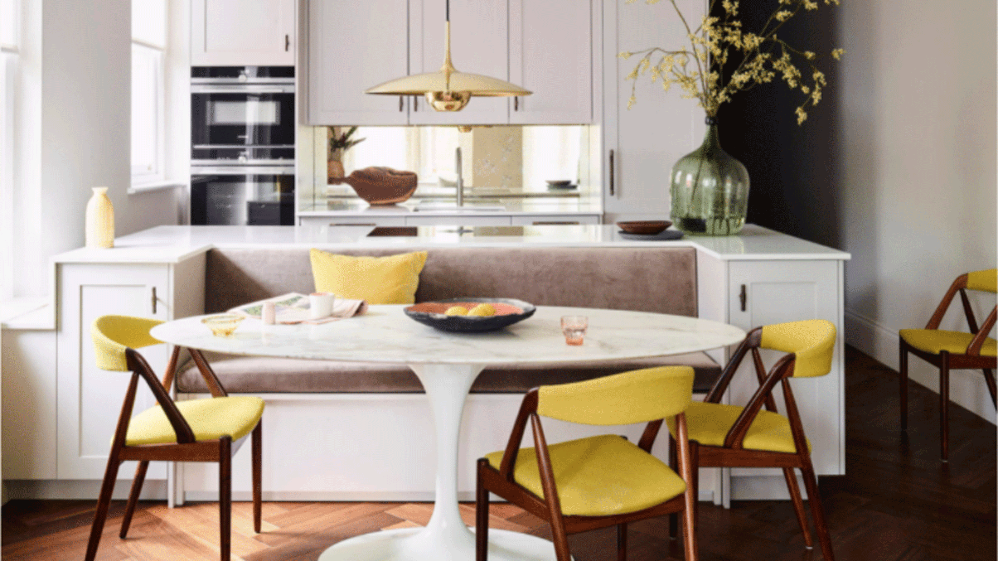 Banquette seating in kitchen with bright yellow chairs