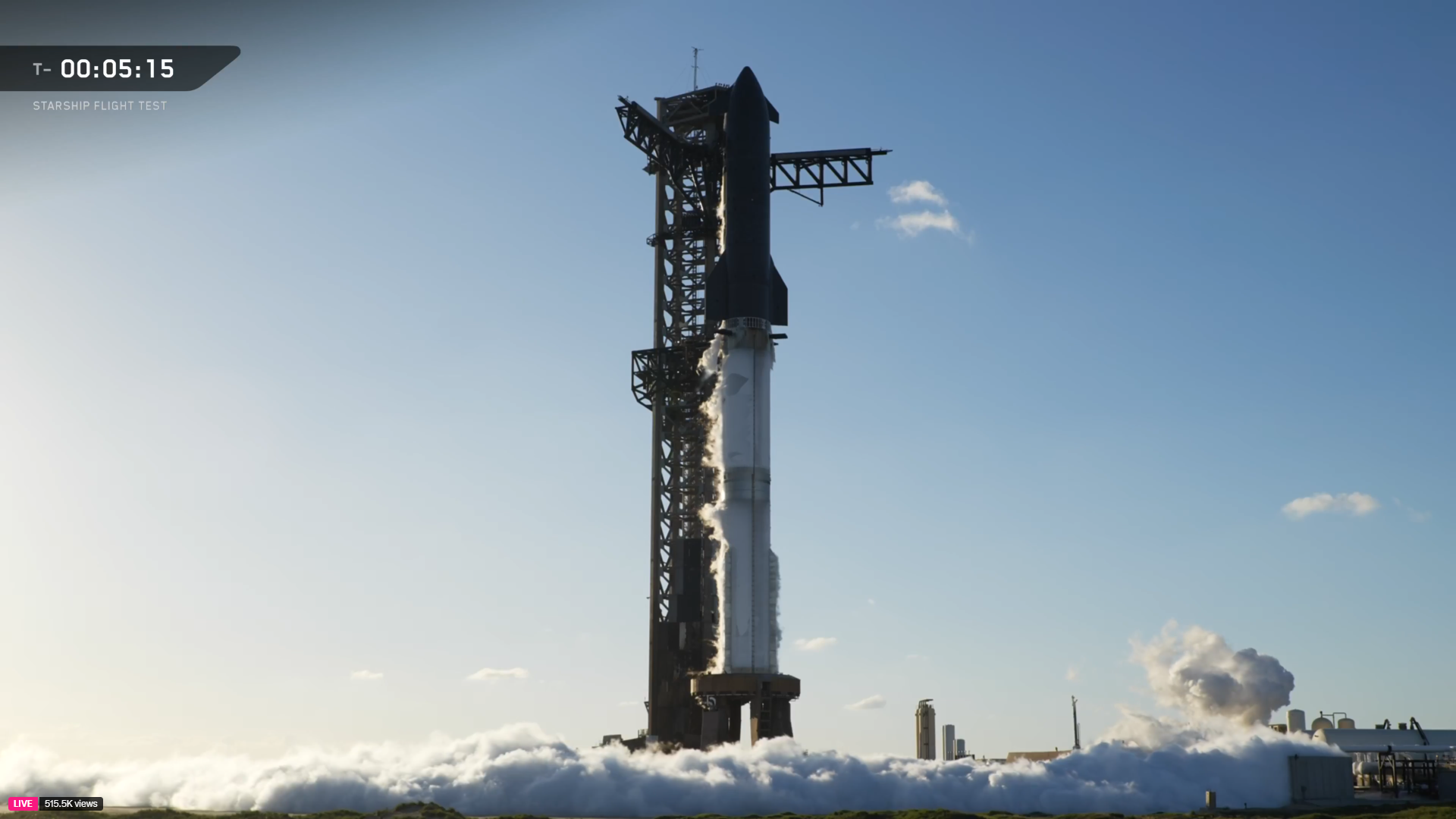 A giant SpaceX Starship Flight 11 rocket is fueled for launch with vapor running around the ground.