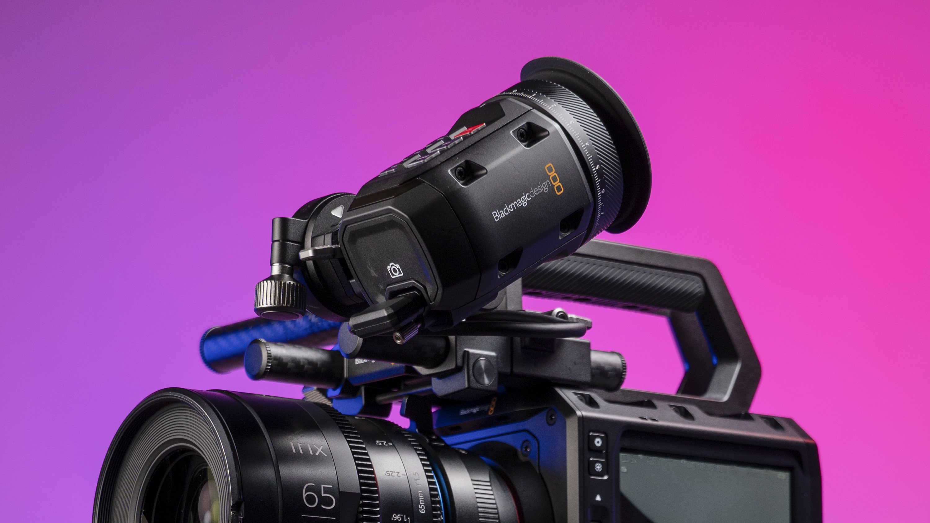 Blackmagic Pyxis 6K camera in the studio, mounted to video tripod, with a vibrant magenta background