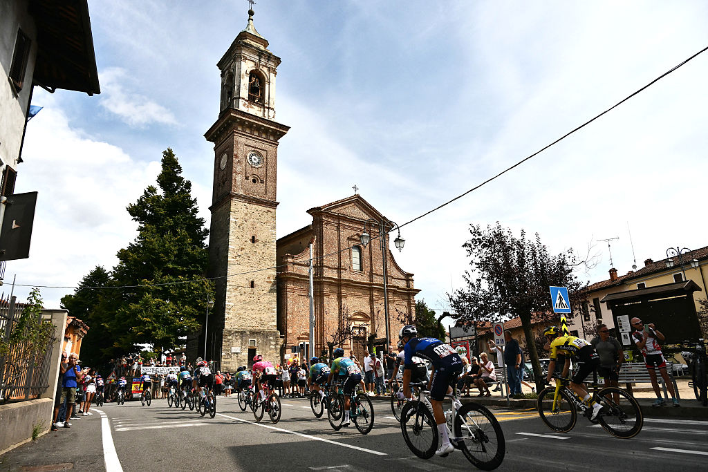 The pack rides in Zubiena during the first stage of the Vuelta a Espana, a 183 km race between Torino - Reggia di Venaria and Novara, in Italy's Piemonte region, on August 23, 2025. (Photo by Marco BERTORELLO / AFP)