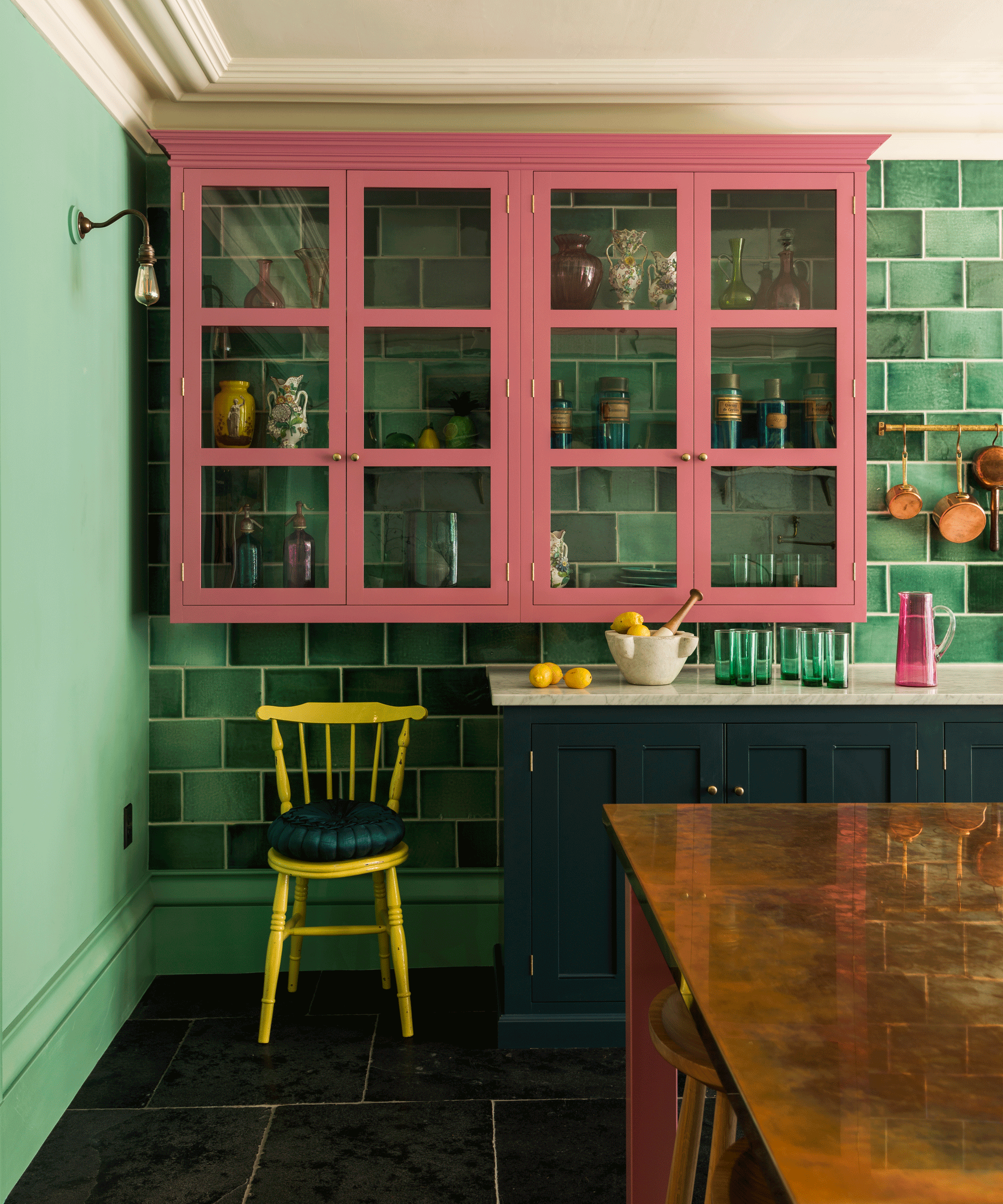 Two-tone kitchen with pink upper units and green tiled walls