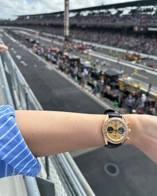 Woman standing over racetrack at the Indy 500 wearing a TAG Heuer Carrera Chronograph watch.