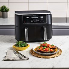 black air fryer in kitchen with food on kitchen island