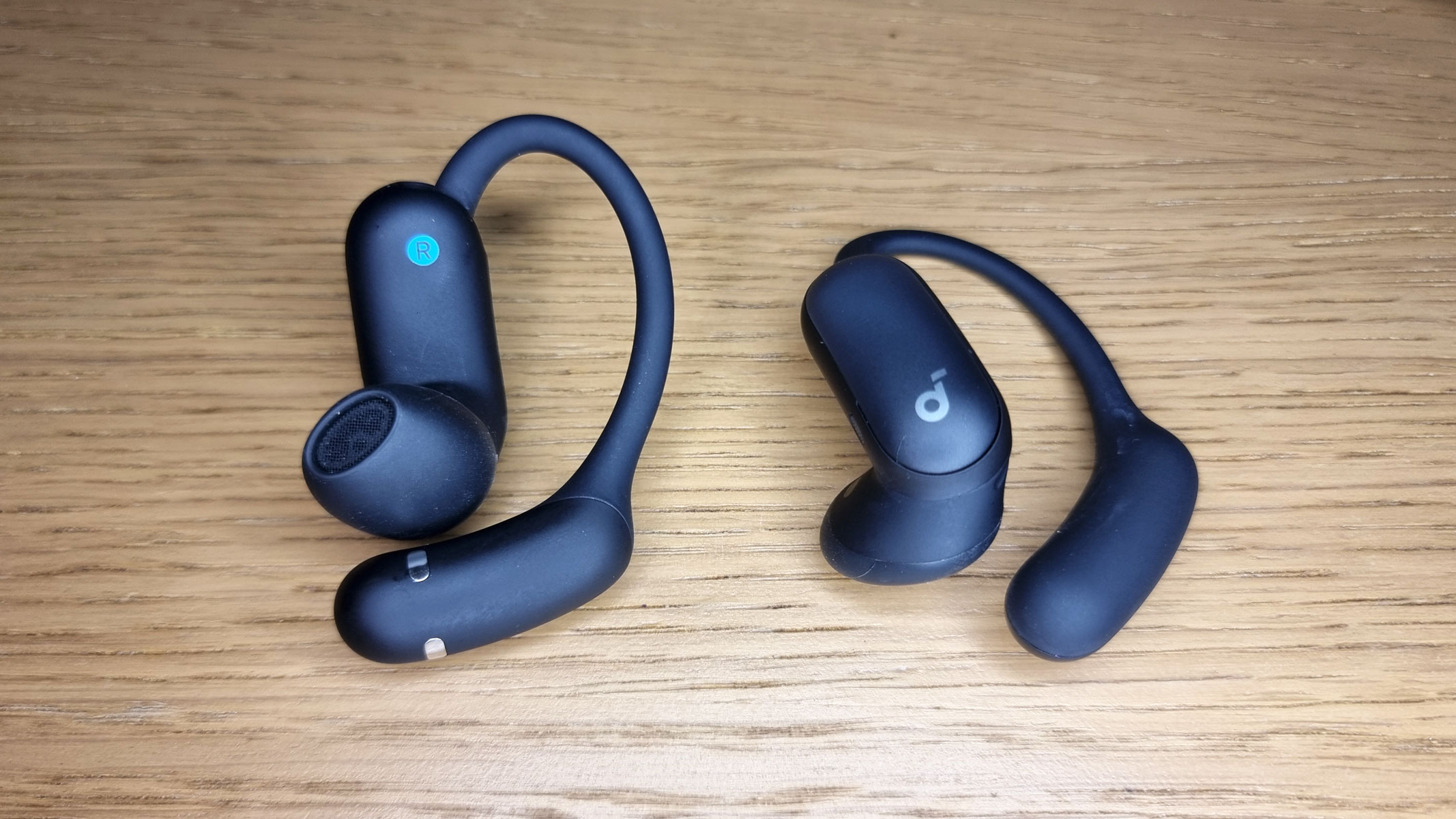 A close-up picture of the Soundcore Aerofit 2 Pro earbuds laid out on a table