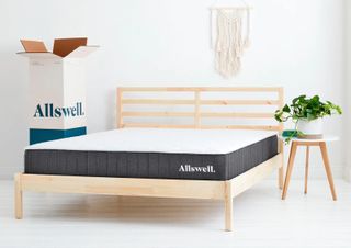 Image shows the Allswell Mattress placed on a light wooden bedframe in a bedroom