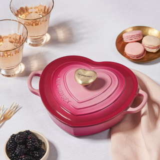 Le Creuset Shallow Heart Cocotte with Light Gold Heart Knob in berry on a dessert table