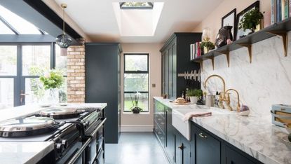 Galley type kitchen with green/black cabinets and white marble countertops