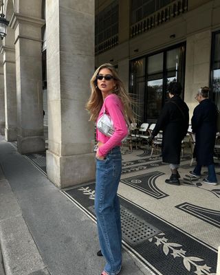 @emilisindlev wearing a silver Fendi baguette bag with pink cardigan and jeans