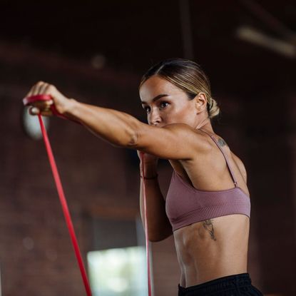 A woman trying some of the advanced resistance band core workouts at the gym