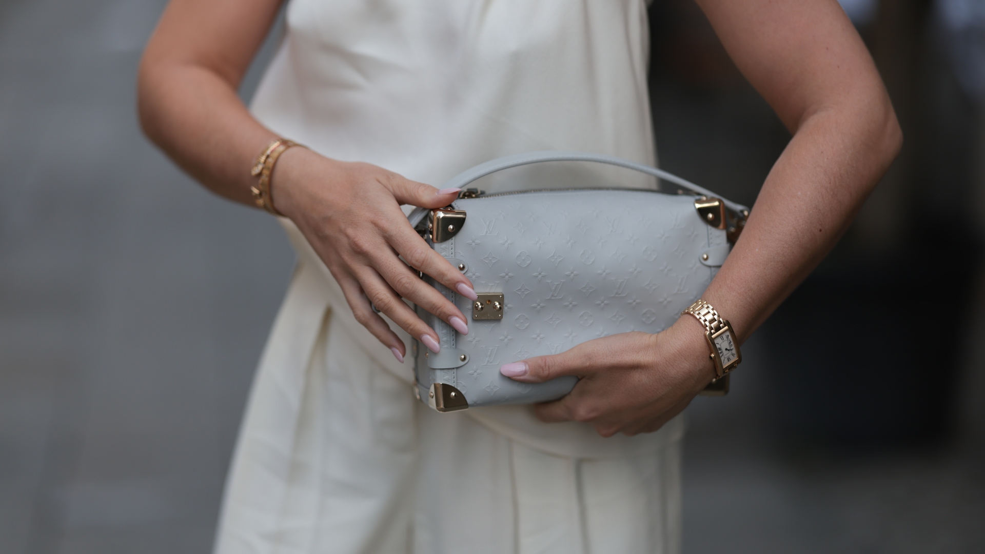 a woman wearing gold rings and neutral nails