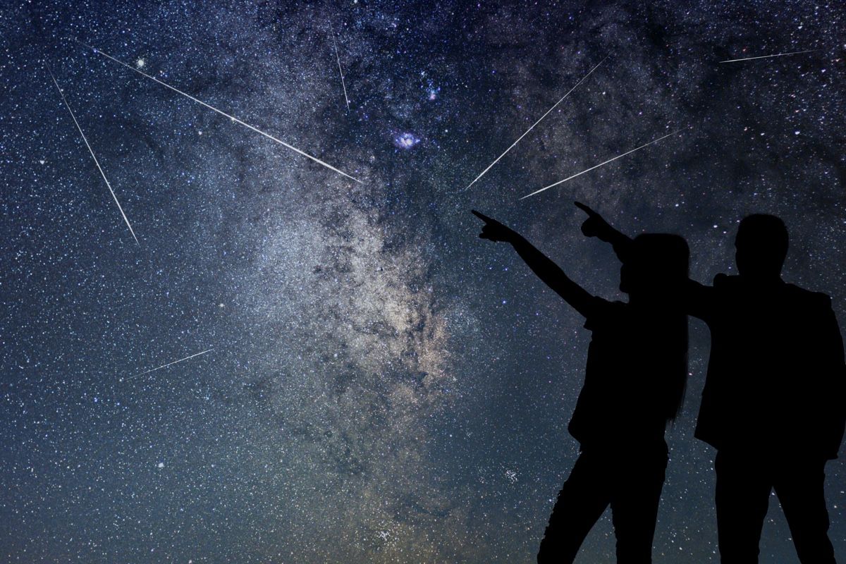 Silhouettes of people watching meteor shower.