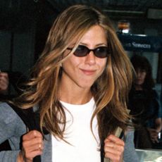 Jennifer Aniston wears a long gray cardigan to the airport in 1999 
