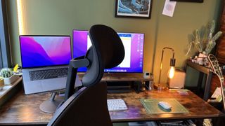 The Herman Miller x Logitech G Vantum gaming chair in a bedroom office with wooden floor and desk.