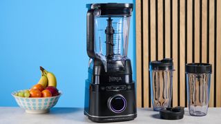 the ninja detect power pro with blendsense, a powerful blender with removable blades, a personal blender attachment, and control dial photographed against a blue background