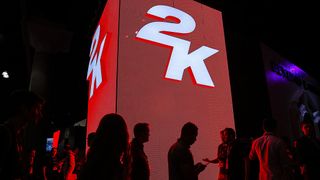 Attendees walk past signage for 2K Games Inc. during the E3 Electronic Entertainment Expo in Los Angeles, California, U.S., on Tuesday, June 10, 2014. E3, a trade show for computer and video games, draws professionals to experience the future of interactive entertainment as well as to see new technologies and never-before-seen products.