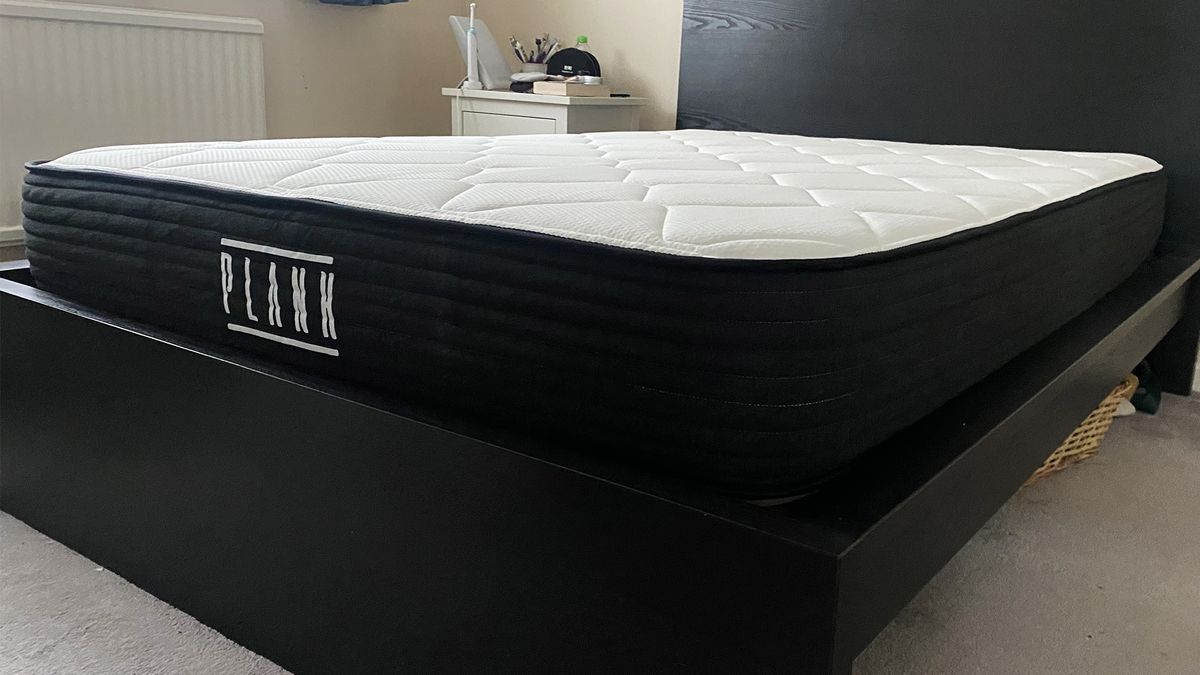 The Plank Firm Mattress (with the Extra Firm side facing upwards) on a black bed frame in our reviewer's bedroom