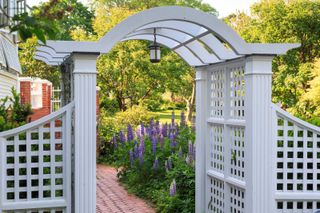 garden arbor ideas: pale grey arch over path
