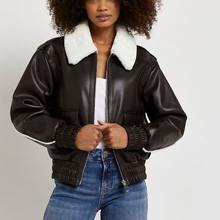 model wearing a river island brown shearling leather jacket with fluffy collar