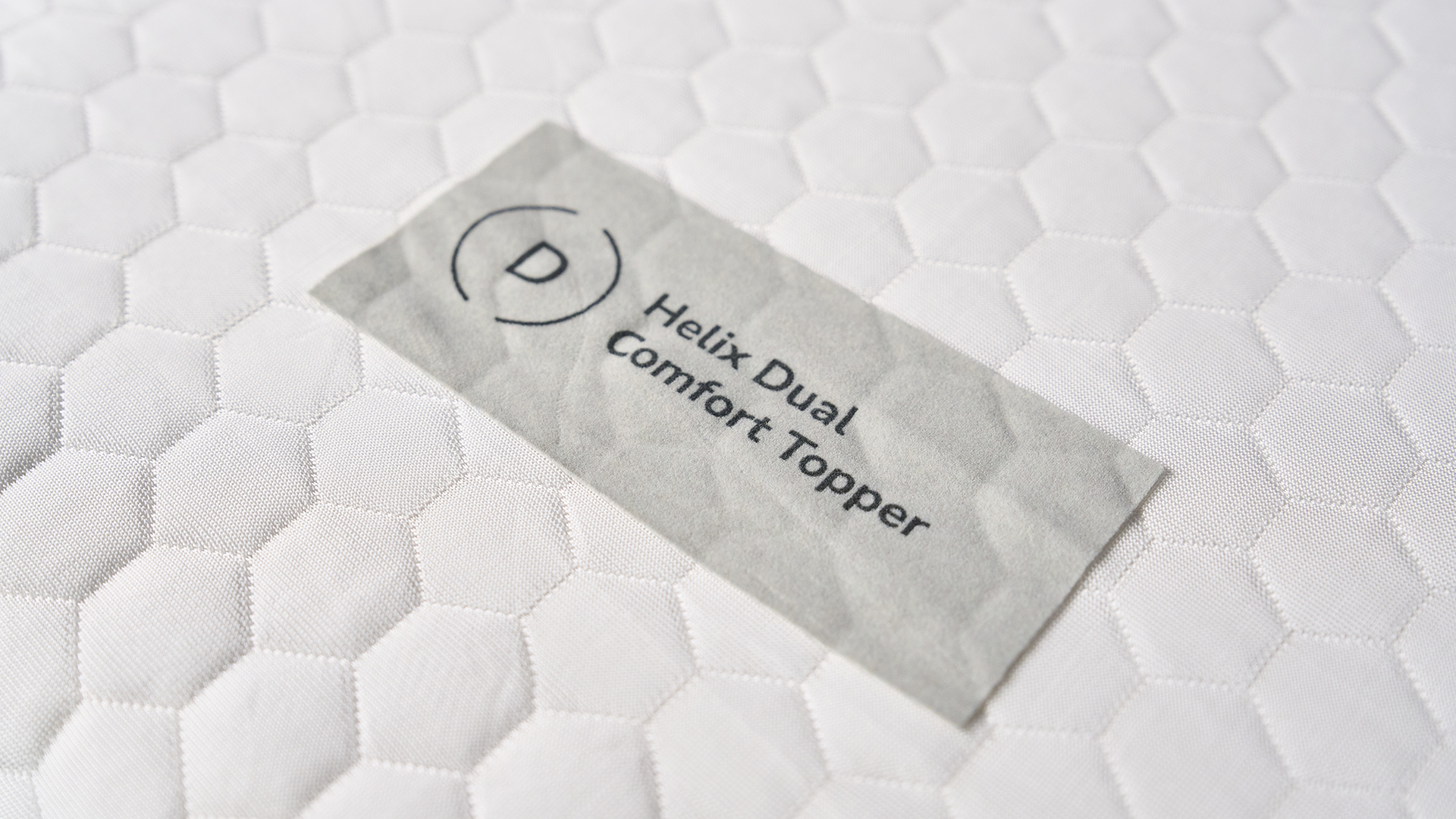 A close-up image of the Helix Dual Comfort Mattress Topper logo. 