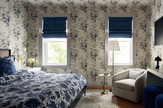 A bedroom with a blue wallpaper and blue bedding