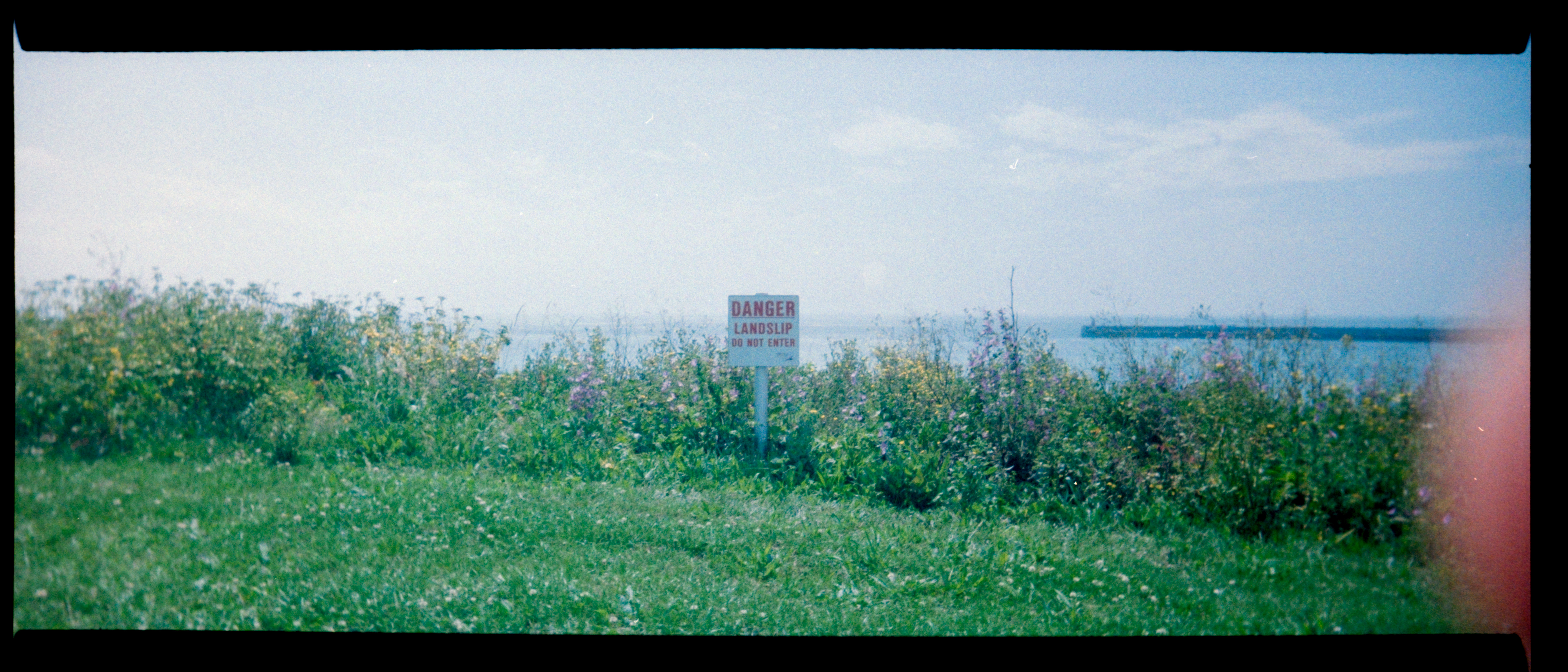 Sign on the edge of the a cliff warning of danger