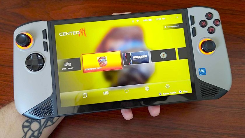Hand holding MSI Claw 8 AI+ in front on woodgrain desk with CentreM software on screen.